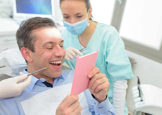 Smiling patient looking at their tooth